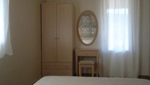 a bedroom with a dresser and a mirror and a bed at House of Garden in Dhráganon