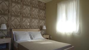 a bedroom with a bed with a window and white sheets at House of Garden in Dhráganon