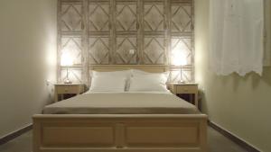 a bedroom with a bed with two lamps on two tables at House of Garden in Dhráganon