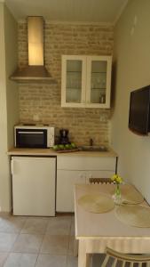 a kitchen with a table and a microwave at House of Garden in Dhráganon
