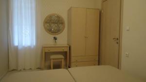 a bedroom with a bed and a desk and a mirror at House of Garden in Dhráganon