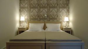 a bedroom with a bed with two lamps on both sides at House of Garden in Dhráganon