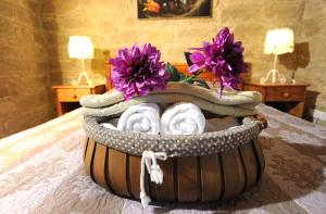 a basket of towels and flowers on a bed at Esperando in Maroni