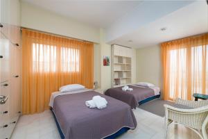 レティムノ・タウンにあるZephyr Luxury Apartmentのベッドルーム1室(ベッド2台、タオル付)