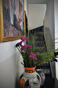 un vaso con fiori su un tavolo con un dipinto di SARDINAS & CHILI a Marrakech