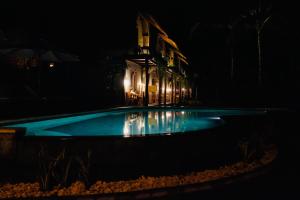 a swimming pool in front of a building at night at Tentacle Bali in Nusa Penida