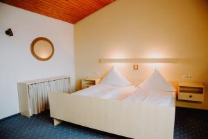 a bedroom with a large white bed with a mirror at Pension Neustart in Bad Buchau +25 photos