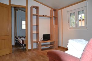 a room with a room with a bed and a tv at Camping Fuentes Blancas in Burgos