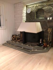 un salon avec une cheminée et une lampe dans l'établissement Leilighet, à Tromsø