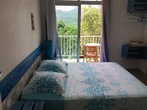 una camera da letto con un letto con vista su un balcone di La Colline Business & Tourisme a Le Lamentin