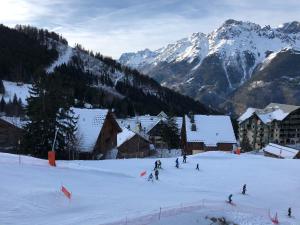 a group of people skiing down a snow covered mountain at *NEW* Bellevue D’Oz Ski In Ski Out Luxury Apartment (8-10 Guests) in Oz