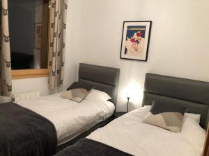 1 dormitorio con 2 camas y una foto en la pared en *NEW* Bellevue D’Oz Ski In Ski Out Luxury Apartment (8-10 Guests) en Oz