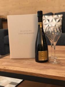 una botella de vino y una copa de vino en una mesa en *NEW* Bellevue D’Oz Ski In Ski Out Luxury Apartment (8-10 Guests) en Oz