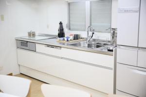 Una cocina blanca con fregadero y refrigerador. en SHINJUKU 5-ROOM Family house, en Tokio 47 fotos más