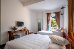 a hotel room with two beds and a window at Vida Loca Sunset Beach Resort in Phu Quoc