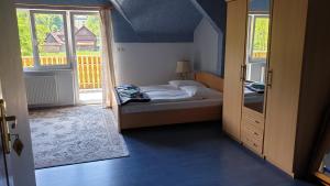 a bedroom with a bed and a door to a balcony at OKW Pilsko in Korbielów
