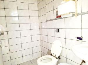 a white bathroom with a toilet and a sink at Orion Hostel Congonhas in Sao Paulo