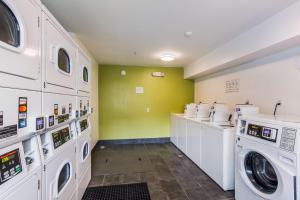 a laundry room with white washing machines and a green wall at Studio 6 Extended Stay - Jacksonville, FL - South in Sunbeam