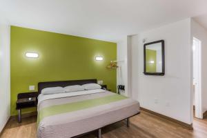 a bedroom with a bed with a green wall at Motel 6-Jacksonville, FL - South in Jacksonville