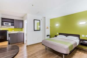a hotel room with a bed and a kitchen at Studio 6-Jacksonville, FL - South in Jacksonville
