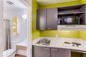 a small kitchen with a sink and a microwave at Studio 6 Extended Stay - Jacksonville, FL - South in Sunbeam