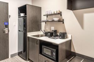 a small kitchen with a sink and a refrigerator at Studio 6-Mesquite, TX - Dallas in Mesquite