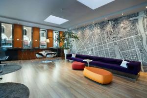 Best Western Plus Executive Hotel and Suites في تورينو: غرفة معيشة مع أريكة أرجوانية وطاولة