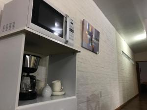 a microwave sitting on top of a shelf at la vidurria -rre in Piriápolis