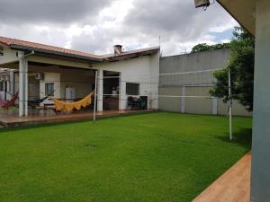a backyard with a large lawn in front of a house at Toca do Gato in Foz do Iguaçu