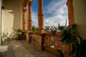 a balcony with columns and a table and a chair at GALA Hotel Boutique in Guadalajara