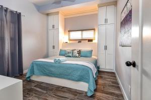 a small bedroom with a bed with blue pillows at Mangata Villas Adults Only in San Pedro +31 photos