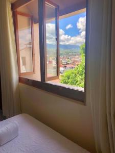 a bedroom with a window with a view of a city at Hotel Monte Azul in Tarapoto