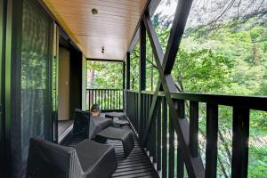 a deck with chairs and a table on a porch at Kyousen in Iida