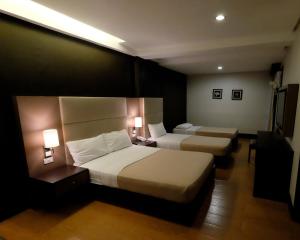 Habitación de hotel con 2 camas y 2 lámparas en 3G Garden Hotel, en General Santos