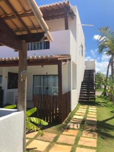 a house with a wooden gate and stairs to it at Gostoso White in São Miguel do Gostoso