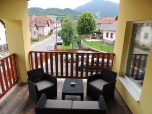 a balcony with two chairs and a table and a view at Vila Danmar - rent whole vila or upper floor apartment in Závažná Poruba