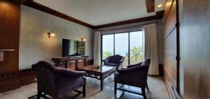 een kamer met een tafel en stoelen en een raam bij Garden Sea View Resort in Noord Pattaya
