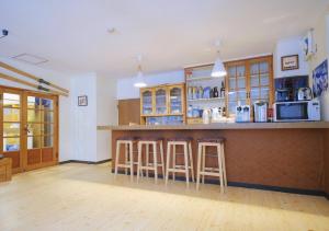 a kitchen with wooden cabinets and bar stools at Snow Elephant in Hakuba
