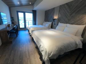Postel nebo postele na pokoji v ubytování Watermark Hotel Kaohsiung Main Station