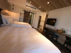 Postel nebo postele na pokoji v ubytování Watermark Hotel Kaohsiung Main Station