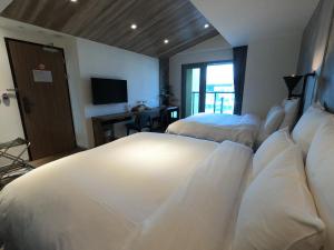 Postel nebo postele na pokoji v ubytování Watermark Hotel Kaohsiung Main Station