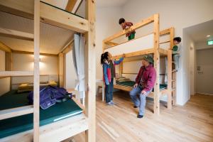 a group of people standing in a room with bunk beds at Mt.Takao Base Camp in Hachioji