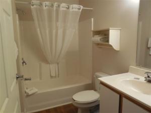 Affordable Suites Gastonia في غاستونيا: حمام ابيض مع مرحاض ومغسلة
