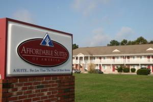 una señal frente a un edificio de apartamentos en Affordable Suites Gastonia en Gastonia