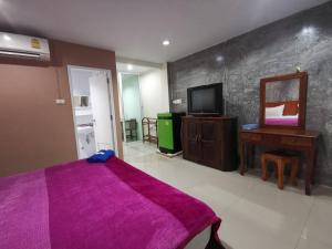 a bedroom with a purple bed and a mirror at Ban Kaew Guesthouse Songkhla in Songkhla