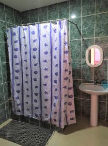 a shower curtain in a bathroom with a sink at Casa Cabral : Big Apartment next to the beach in Tarrafal