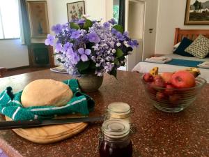 a table with a bowl of fruit and a vase of flowers at Sanfern Downs Cottage in Haenertsburg