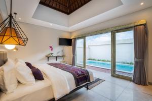 a bedroom with a large bed and a large window at La Numa Villas Canggu in Canggu