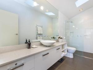 La salle de bains blanche est pourvue d'un lavabo et de toilettes. dans l'établissement The Quarterdeck, à Port Fairy