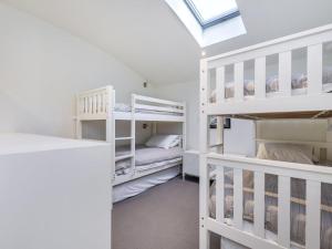 - une chambre avec des lits superposés blancs et une lucarne dans l'établissement The Quarterdeck, à Port Fairy